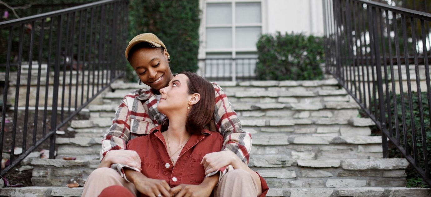 pareja-trans-sentada-escaleras-siendo-carinosa_23-2149304558