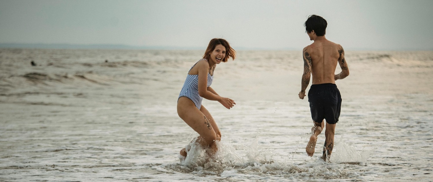 Pareja disfrutando en la playa, ejemplo de bienestar emocional en la relación